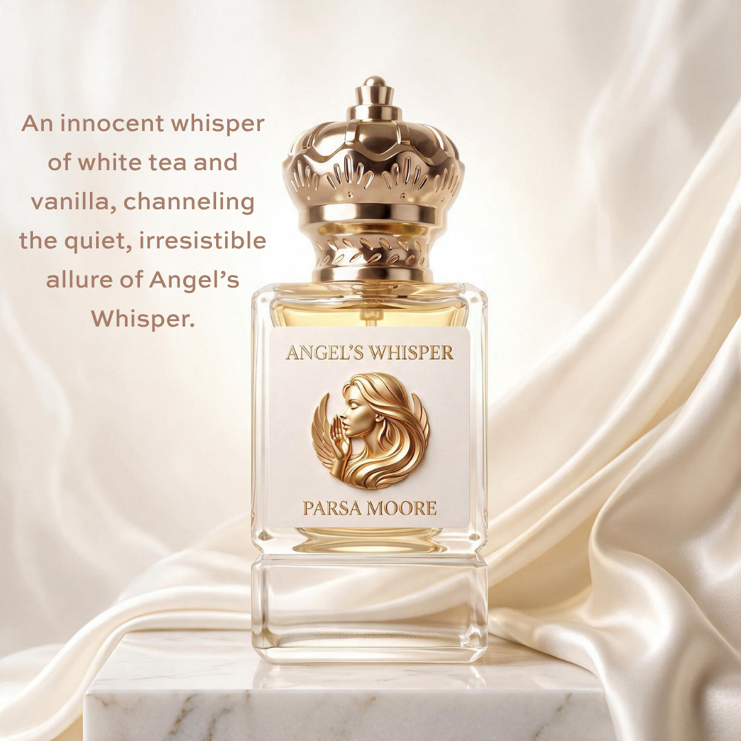 A perfume bottle labeled 'ANGEL'S WHISPER' by 'PARSA MOORE' sits on a marble surface against a draped satin backdrop. The bottle is clear glass with pale yellow liquid, a white label featuring a gold profile illustration and text, and a metallic gold crown cap.