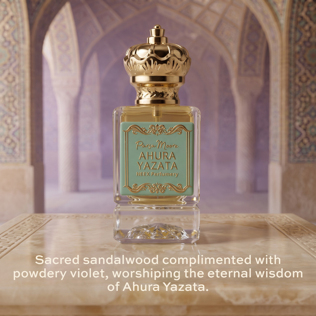 A perfume bottle labeled 'Parsa Moore AHURA YAZATA' stands centered on a stone surface with a blurred architectural background. The bottle is clear glass with a gold cap and a pale aqua label.